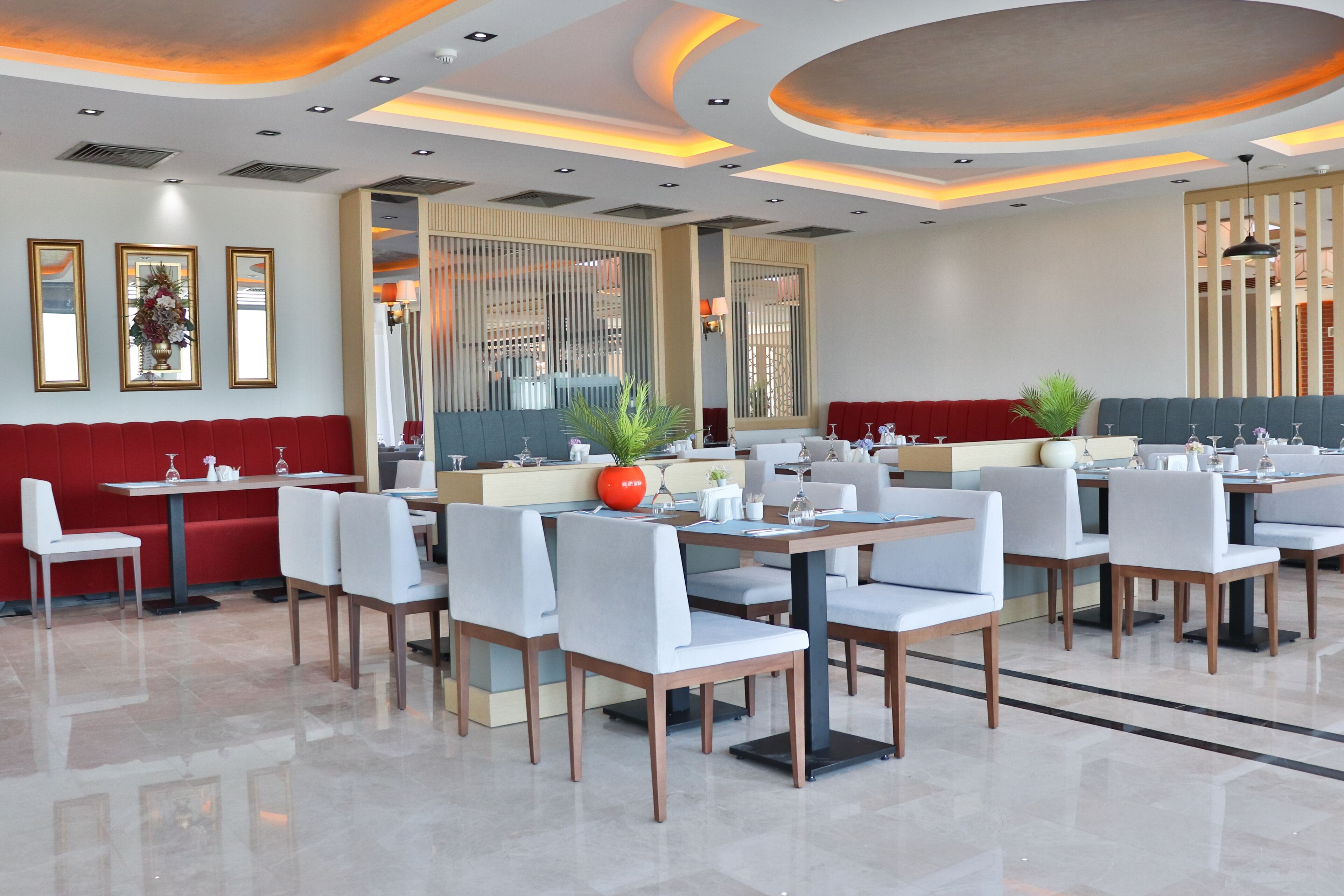 Un restaurante moderno con un diseño limpio y minimalista, que ofrece una variedad de opciones de asientos, como cabinas y mesas.