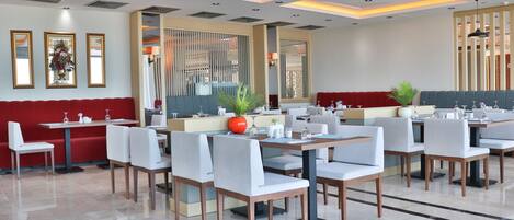 Un restaurante moderno con un diseño limpio y minimalista, que ofrece una variedad de opciones de asientos, como cabinas y mesas.