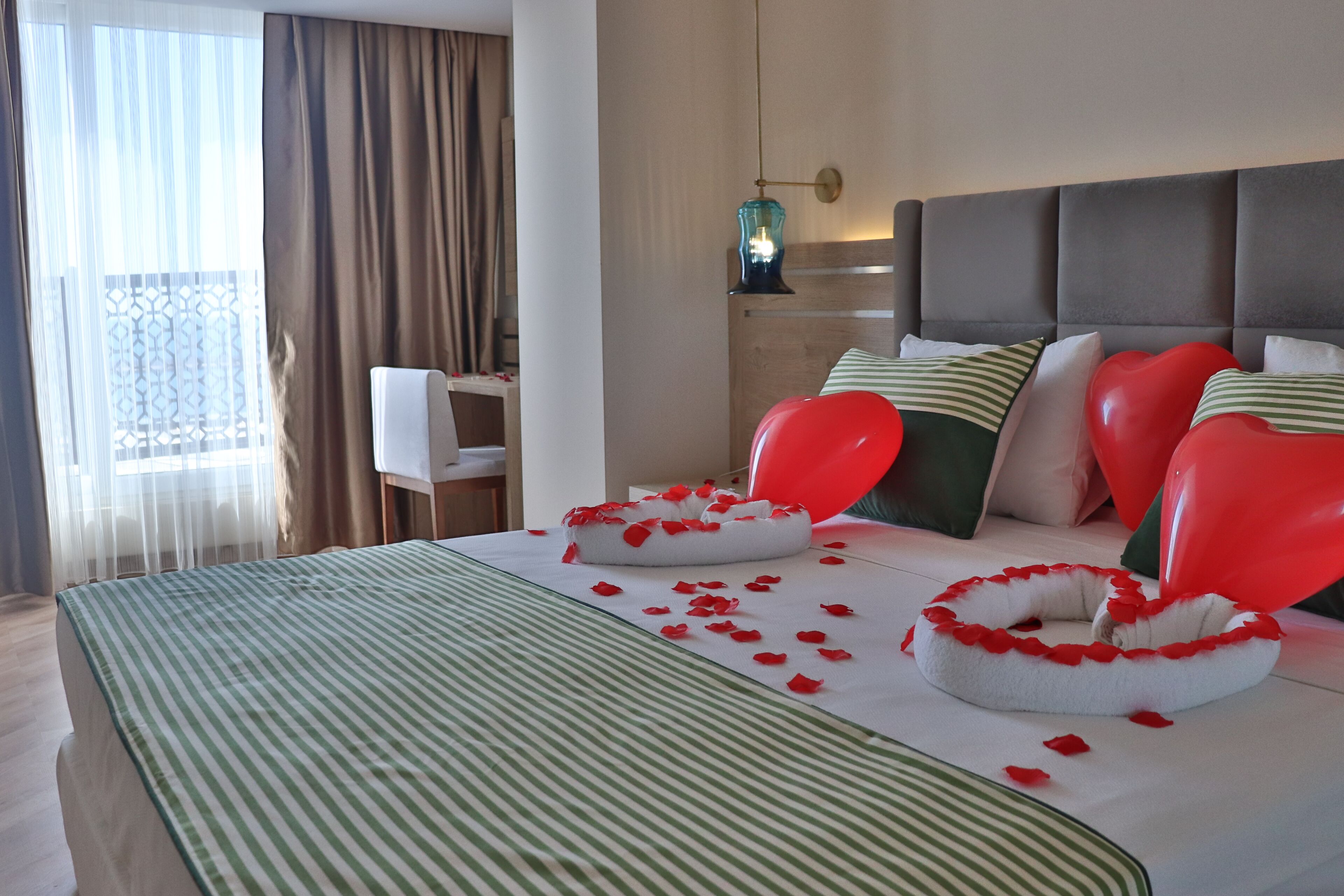 A hotel room with a bed, pillows, and a bedside table.
