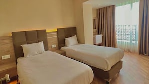 A hotel room with two beds, wooden flooring, and a large window with curtains. - The Sign Degirmen Hotel & Spa (Sile)