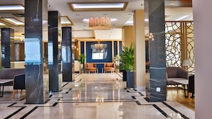 A modern lobby with marble columns, a central seating area, and a geometric decorative wall. - The Sign Degirmen Hotel & Spa (Sile)