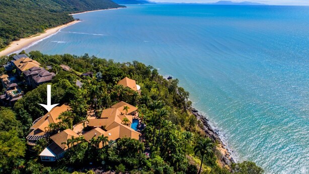 An aerial view of a coastal property with multiple buildings, a beach, and a large body of water. - MUNBILLA 6 @ PALM COVE (PALM COVE)