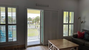 Una habitación con una mesa de madera, un sofá y vistas a una piscina y zona exterior.