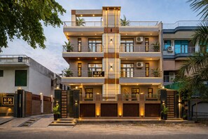 A multi-story residential building with a modern design, featuring balconies, large windows, and a gated entrance. - Hotel Diamond Stay by ASPL (Noida)