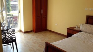 A bedroom with a bed, nightstand, and a window with a view of a balcony. - 20/20 Guest House (Addis Ababa)