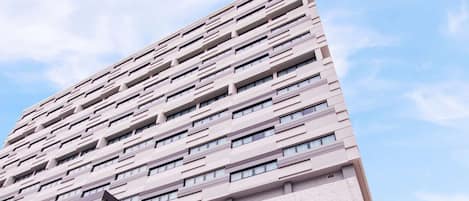 Un edificio alto de hotel con un cartel que dice "Best Western Nada Don Mueang Airport Hotel".