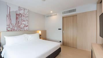 Una habitación de hotel moderna con una cama grande, una mesita de noche, una obra de arte en la pared, un armario de madera y un televisor.