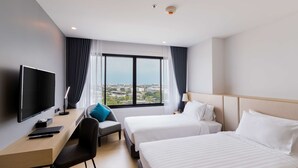 A hotel room with two beds, a desk with a TV, a chair, and a view of the city. - Best Western Nada Don Mueang Airport Hotel (Bangkok)