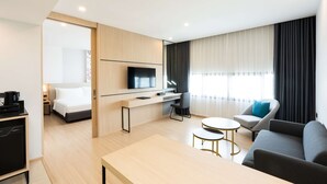 A modern hotel room with a bed, desk, TV, sofa, and a small dining table. - Best Western Nada Don Mueang Airport Hotel (Bangkok)