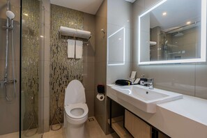 A modern bathroom with a glass-enclosed shower, a white toilet, and a large mirror above a white sink. - Best Western Nada Don Mueang Airport Hotel (Bangkok)