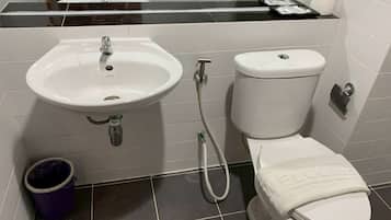 A bathroom with a white sink, toilet, and a bidet.