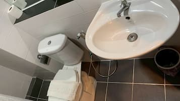 A bathroom with a toilet, sink, and a towel with 'WELCOME' written on it.