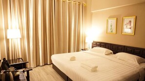 A hotel room with a bed, a desk, a lamp, and curtains. - Taris Art Hotel Phrae (Phrae)