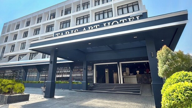 A modern hotel with a prominent entrance and a sign reading "TARIS ART HOTEL". - Taris Art Hotel Phrae (Phrae)