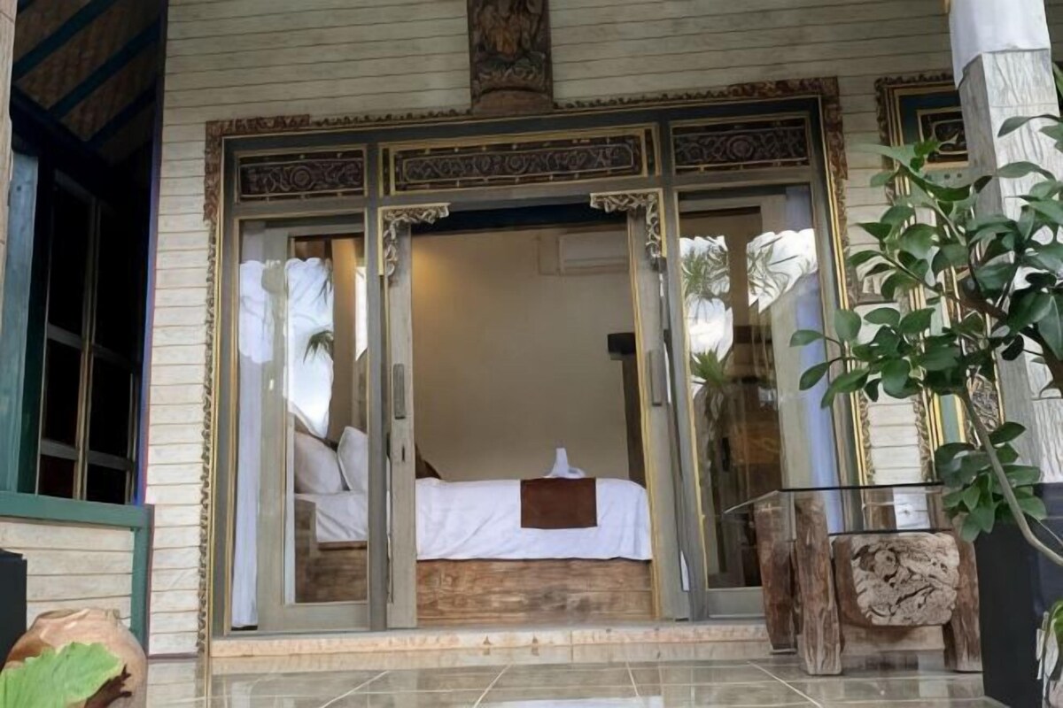 A room with a bed, a window, and a door.