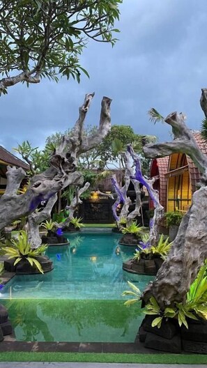 A pool area with naturalistic rock formations and tropical plants. - Villa Telaga Wana (Celuk)