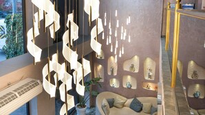 A modern interior with a sofa, a round table, and a unique hanging light fixture. - actuel life hotel (Istanbul)
