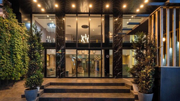 The exterior of the Actuel Life hotel with a modern facade, large glass entrance, and steps leading up to the door. - actuel life hotel (Istanbul)