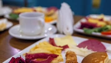 Un buffet de petit-déjeuner proposant divers plats, notamment des crêpes, des œufs et des légumes.