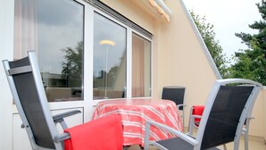 Un comedor con una mesa, sillas, un ventanal y una puerta.