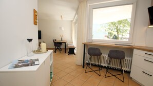 A compact kitchen with a dining area, a window with a view, and a small table with chairs.