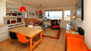 Una cucina moderna con zona pranzo, divano e vista sul mare.