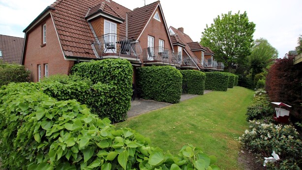 A row of brick houses with sloped roofs and balconies. - Ferienwohnung mit 2- Zimmern auf ca. 35m² (Wyk auf Föhr)