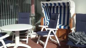 A patio area with a round table and four striped chairs.
