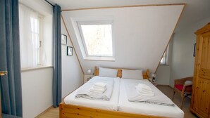 Ein Zimmer mit Bett, Fenster und Kleiderschrank.