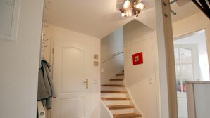 A staircase with wooden steps and a white door. - Ferienwohnung mit 3- Zimmern Über ca. 100m² im Obergeschoß und Spitzboden (Wyk auf Föhr)