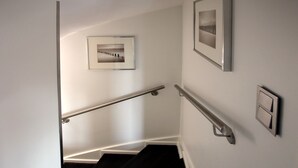 Eine Treppe mit Geländern und Bilderrahmen an den Wänden.