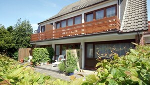 Et toetagers hus med balkon, have og en lille patio.
