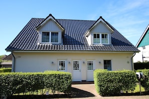 Ein zweistöckiges Haus mit Ziegeldach, einer Haustür und einem Briefkasten.