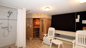 A bathroom with a shower, two white chairs, a wooden sauna, and a window. - Ferienwohnung mit 3 Zimmern, Sehr Komfortabel und Komplett Renoviert auf 58 m² (Wyk auf Föhr)