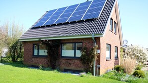 A house with a sloped roof, solar panels, and a brick exterior. - Ferienwohnung mit Garten, Insgesamt 6- Zimmern, 4 SZ und 3 Bädern auf ca. 160qm (Wrixum)