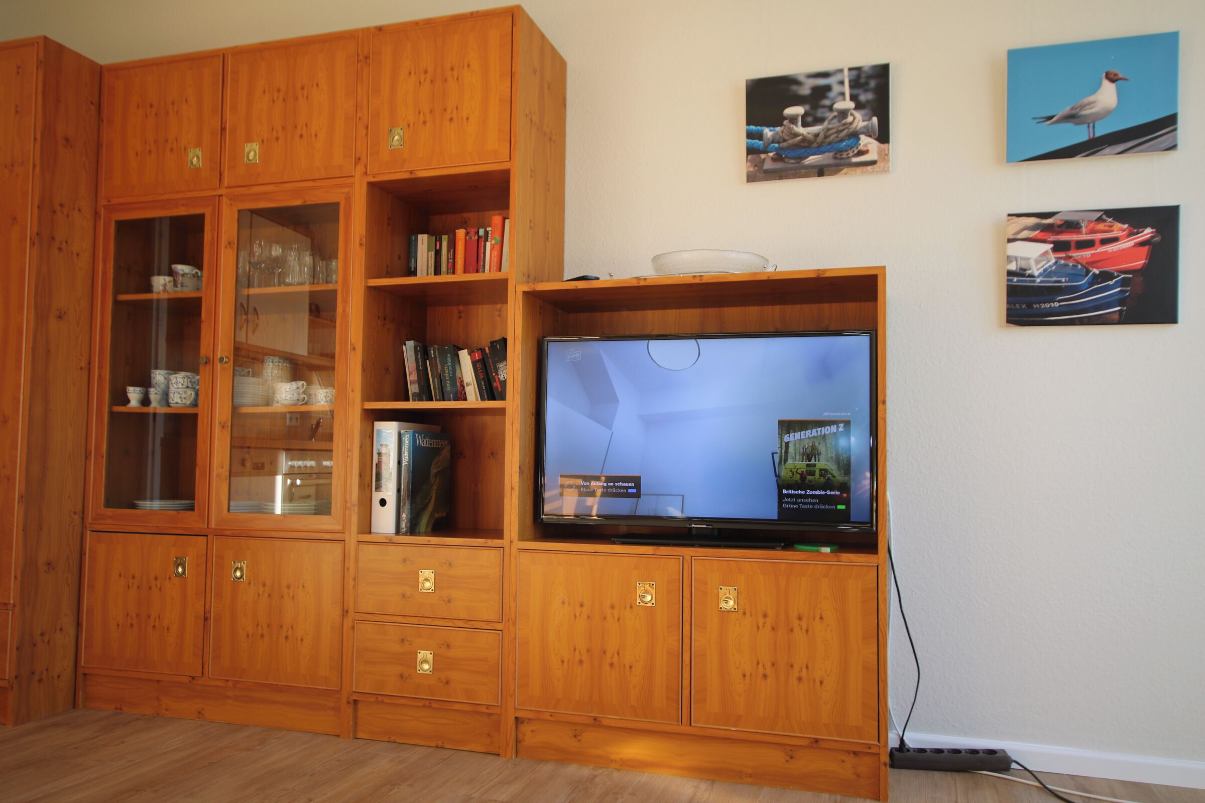 Un mueble de madera con un televisor de pantalla plana, libros y objetos decorativos.