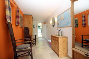 A hallway with wooden furniture, a map on the wall, and a wooden cabinet.