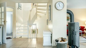 Ein modernes Wohnzimmer mit Treppe, Kamin und einer Wanduhr.