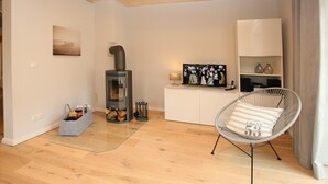 Una sala de estar moderna con chimenea, televisor y un sillón cómodo.