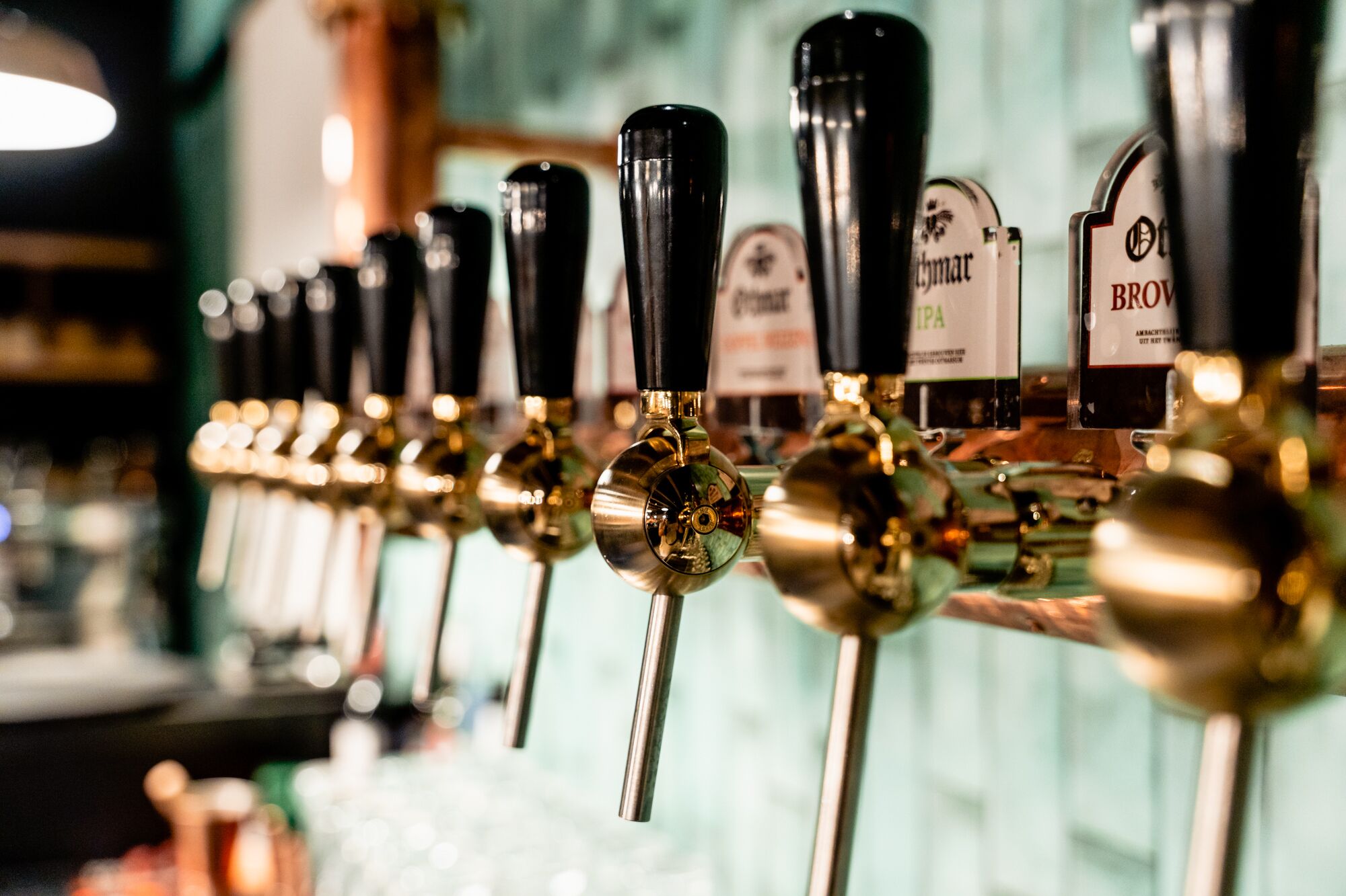 A row of beer taps with labels, including brands like 'Brewmar' and 'IPA'.