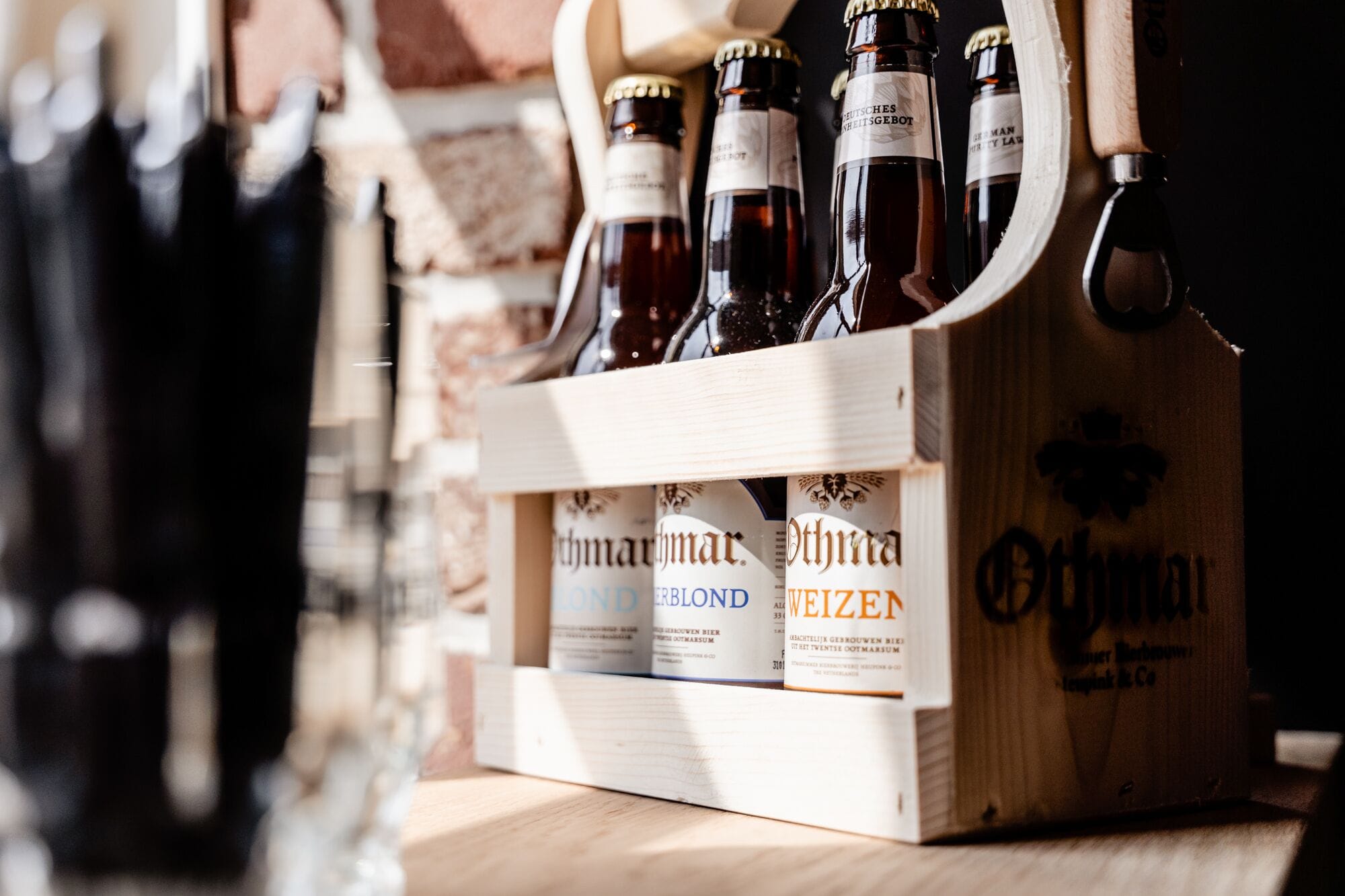 A wooden crate containing bottles of beer with labels visible.
