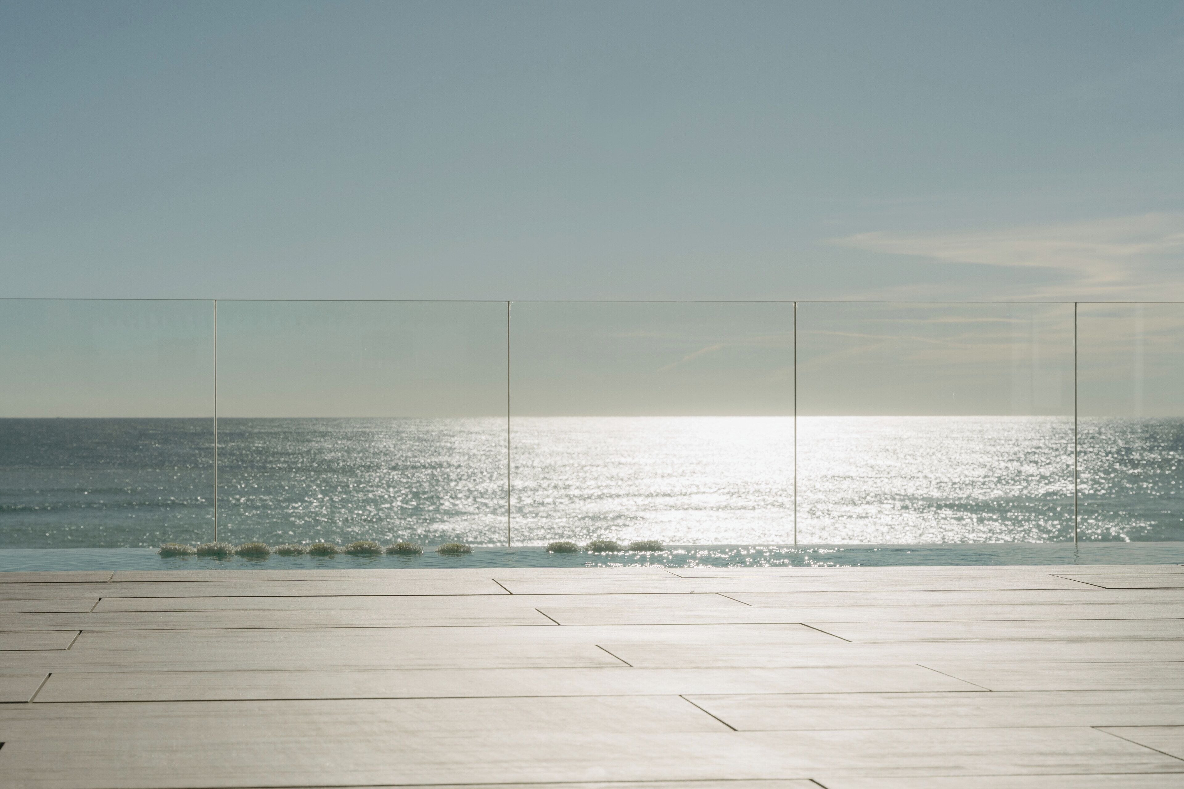 Un amplio espacio al aire libre con vista despejada al océano y una terraza de madera.