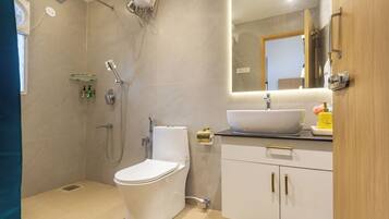 A modern bathroom with a toilet, shower, and sink.