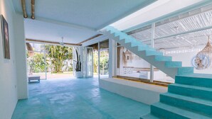 A spacious interior with a blue staircase, large windows, and a view of the outdoors. - Guru Canggu (Canggu)