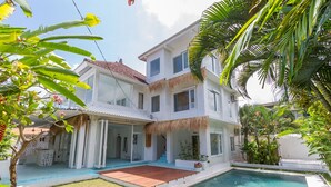A two-story house with a swimming pool, a covered patio, and a thatched roof. - Guru Canggu (Canggu)