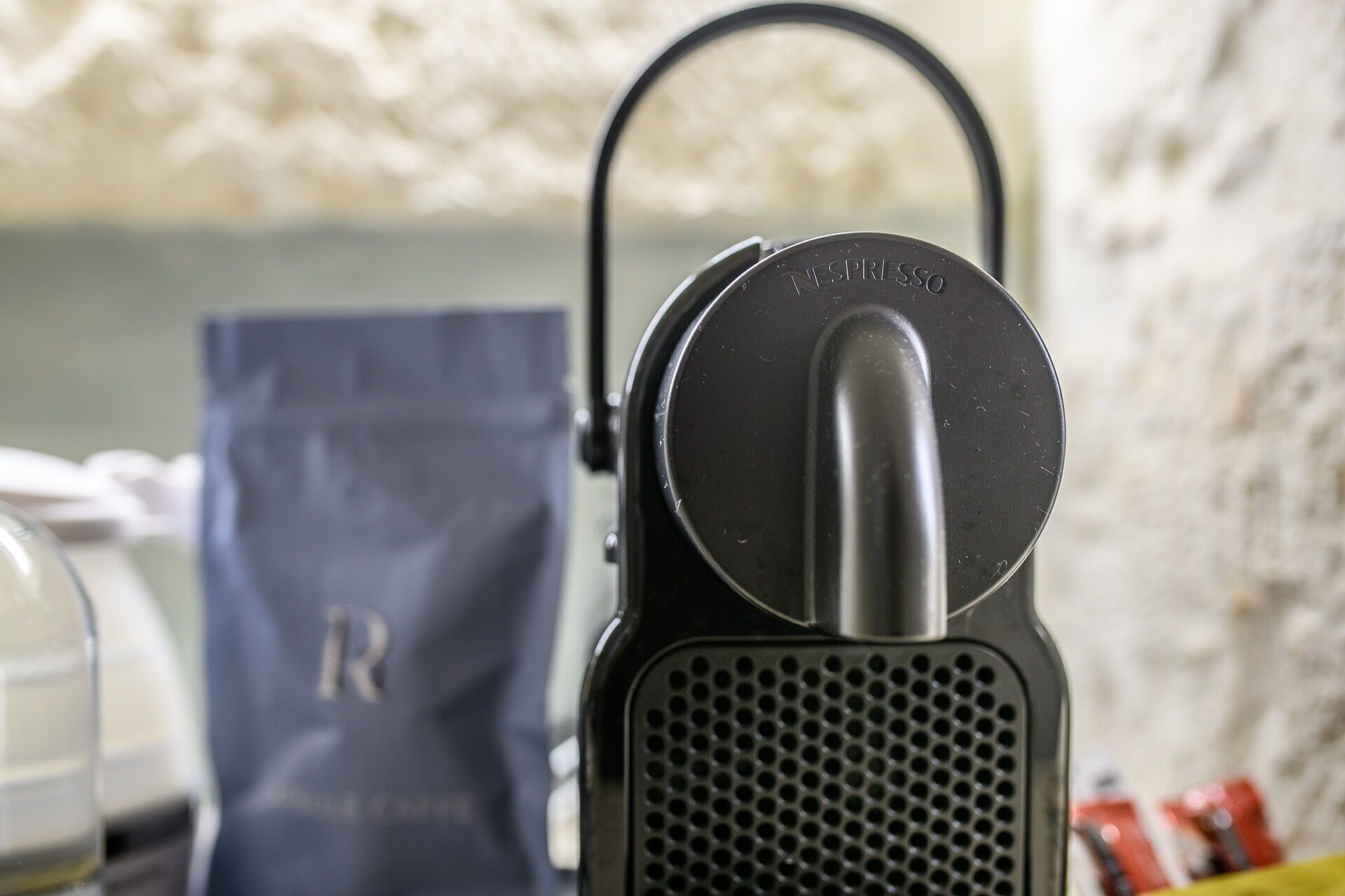 A black Nespresso coffee machine with a water reservoir and a drip tray.