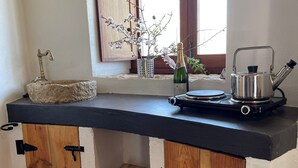 A kitchen with a stone sink, wooden cabinets, a window with a view, and a kettle on the counter. - Beautiful mill and views, in the hinterland of the Algarve coast line.<br> (Alcantarilha)