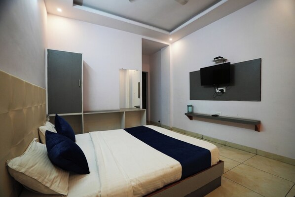 A modern bedroom with a bed, bedside tables, a TV, and a mirror.