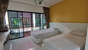 Een hotelkamer met twee bedden, een kroonluchter, een balkon met uitzicht op groen en een groot raam met gordijnen.