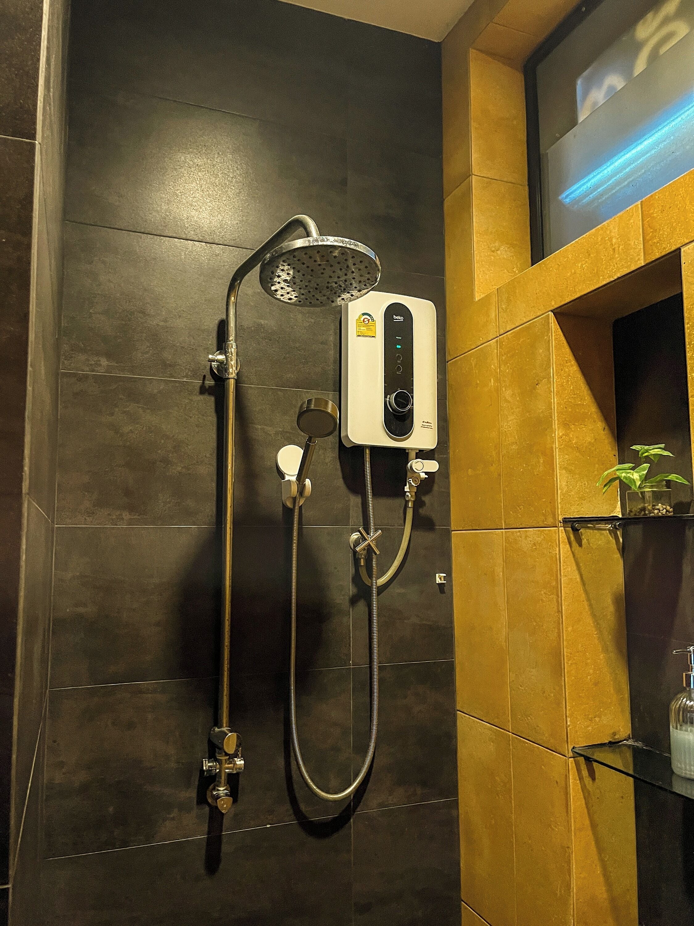 Een moderne badkamer met een wanddouche, een handdouche en een apart douchehandstuk.
